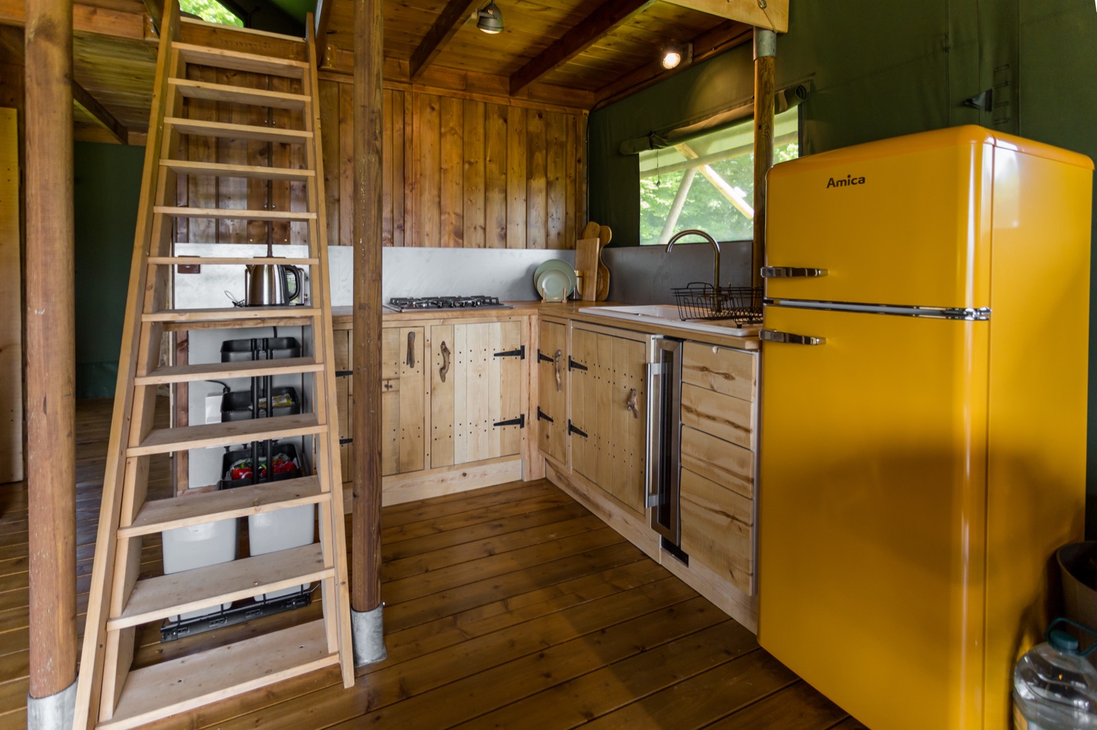 The equipped kitchen with gas hob and fridge