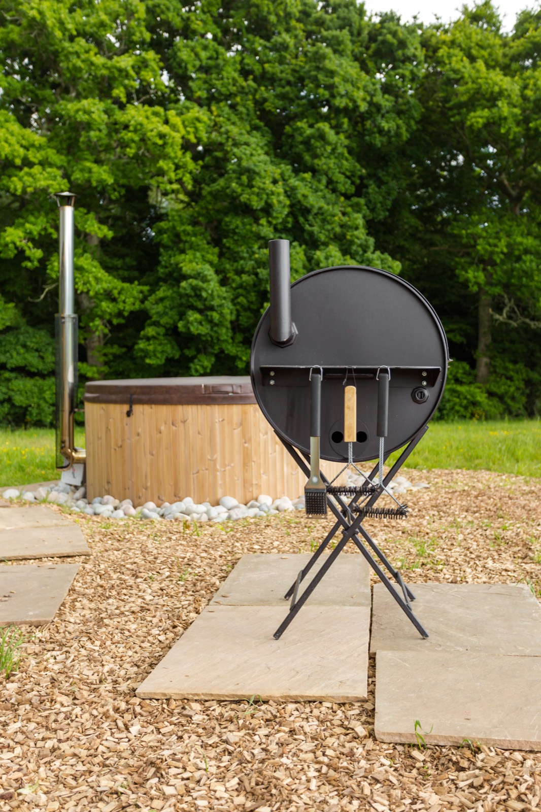 A barrel BBQ beside the hot tub