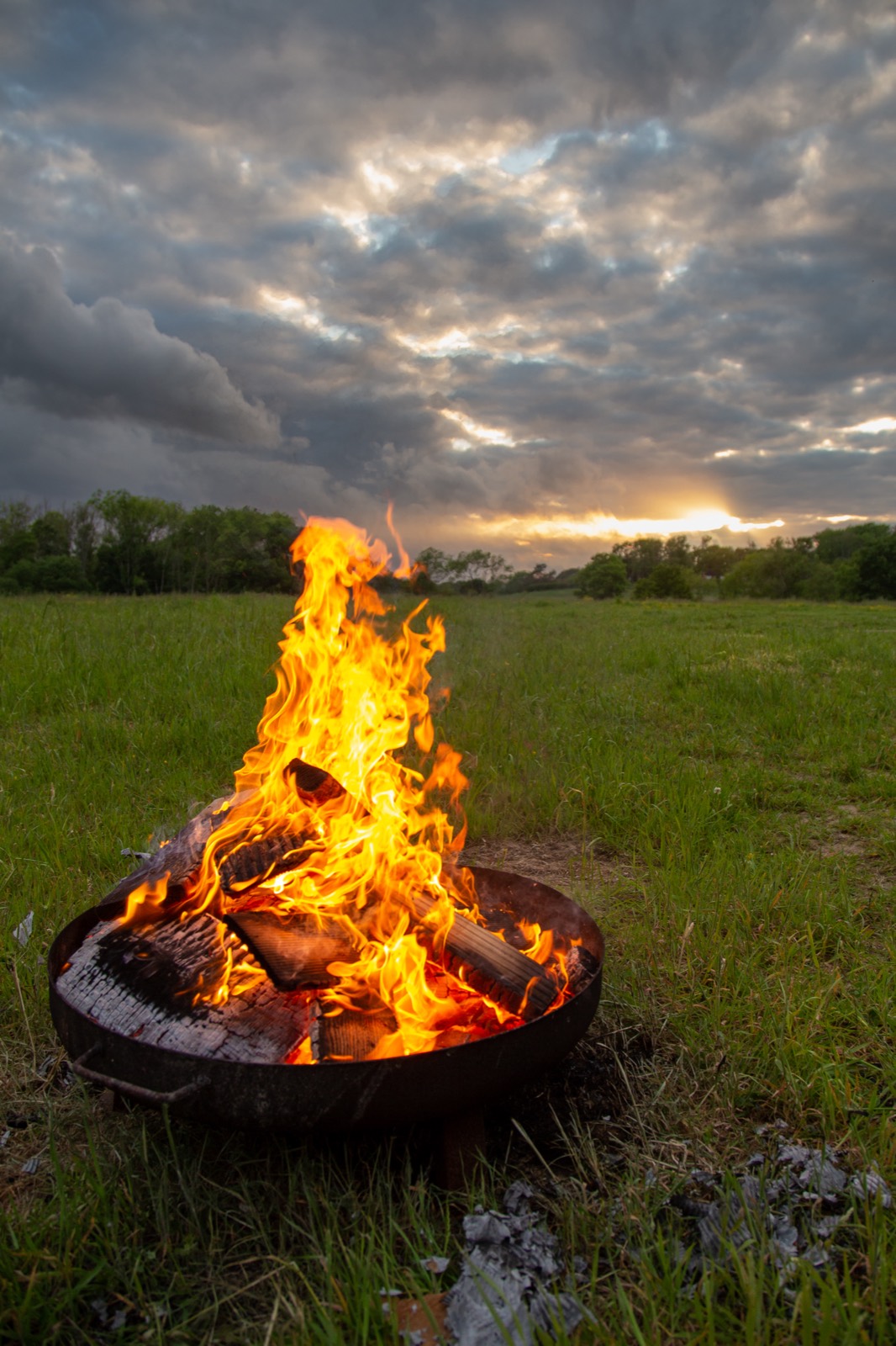 A fire pit blazing at sunset
